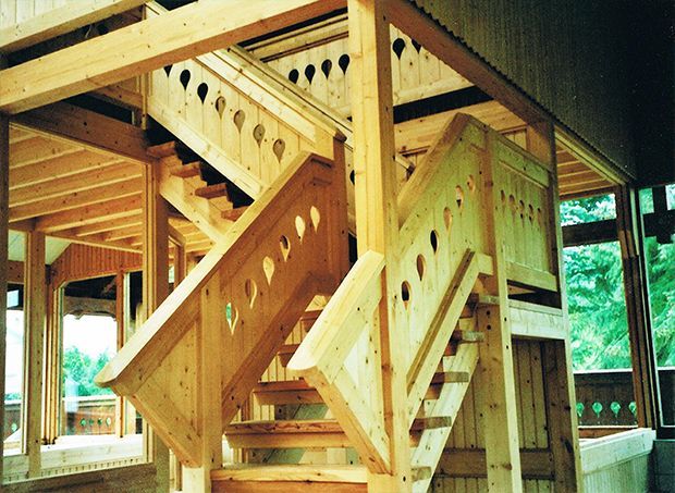 Holztreppe mit dekorativen Ausschnitten, Innenbereich.