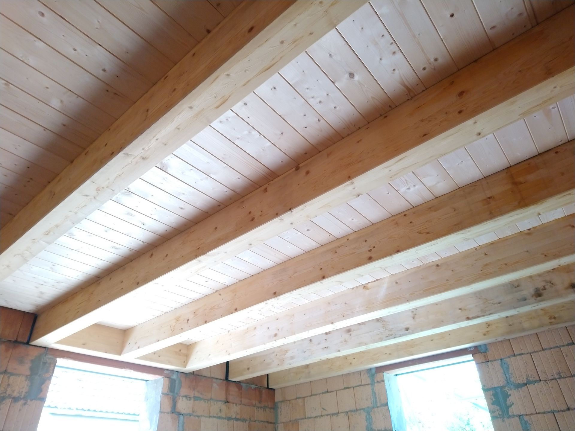 Holzbalken und -planken bilden die Decke in einem im Bau befindlichen Gebäude.