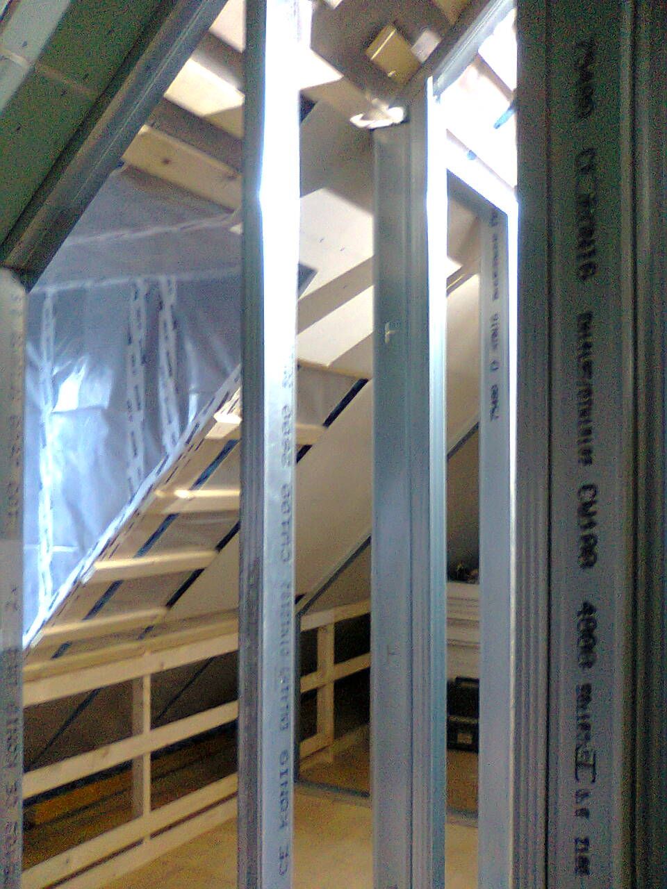 Innenkonstruktion einer im Bau befindlichen Treppe mit Metallständern und Holzbalken.