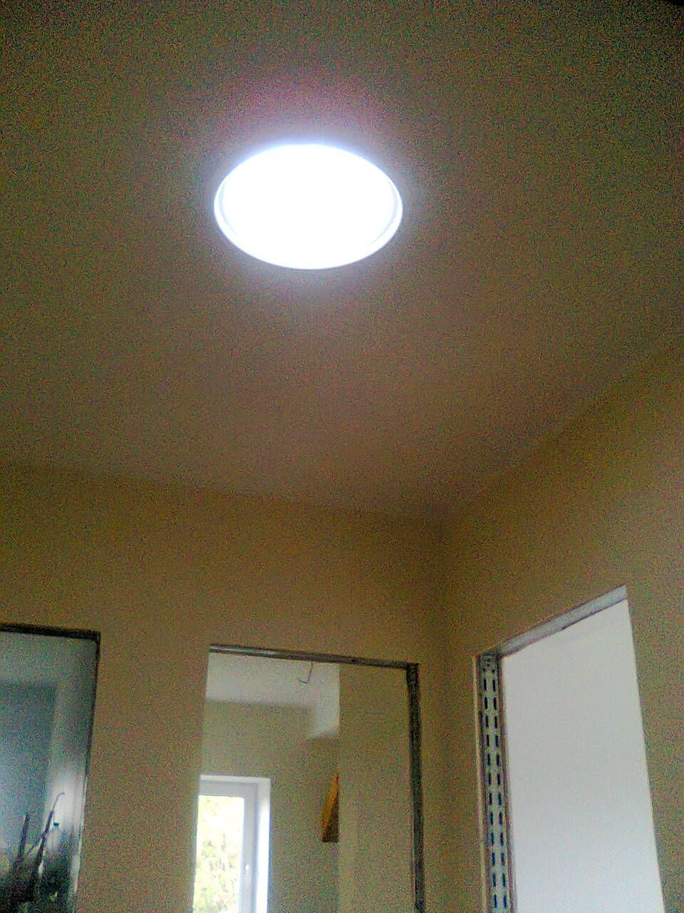 Treppe mit weißen Balustern, hölzernem Handlauf und Stützbalken an einer Backsteinmauer.