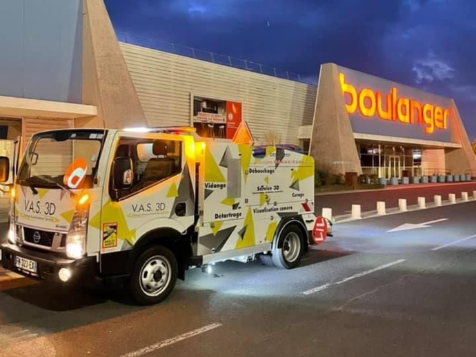 Un pick-up Ford Ranger noir et blanc avec tuba, pare-buffle et graphismes personnalisés, garé sur l'herbe.