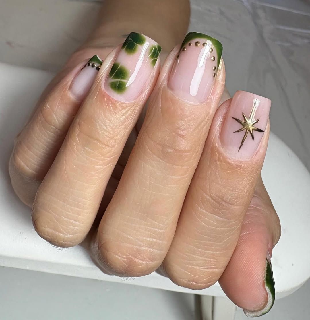 Mano con manicura rosa nude y uñas decoradas con flores descansando sobre una suave manta rosa.