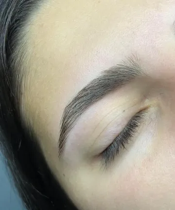 Primer plano de un ojo cerrado con una ceja oscura bien definida sobre piel clara.