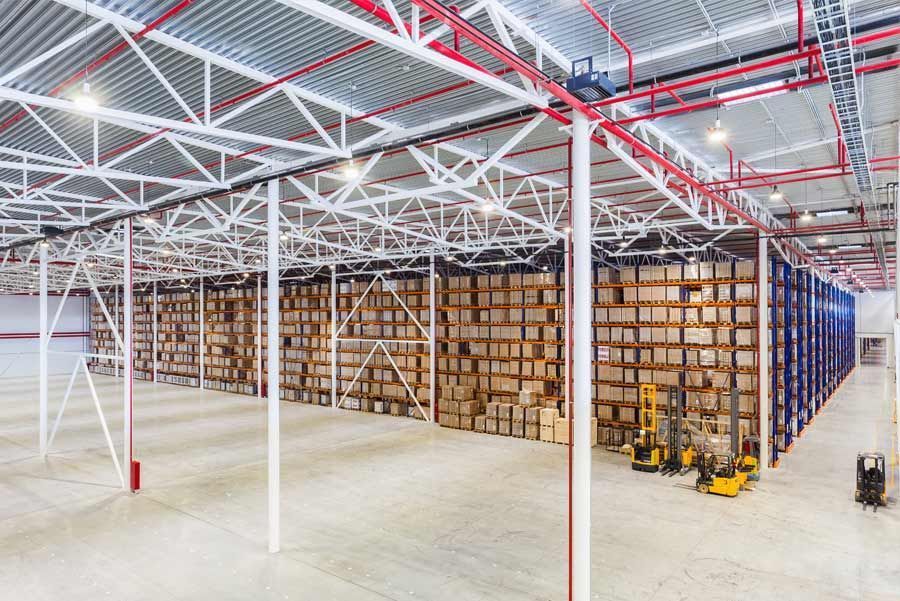 Un gran almacén lleno de muchas cajas y carretillas elevadoras.