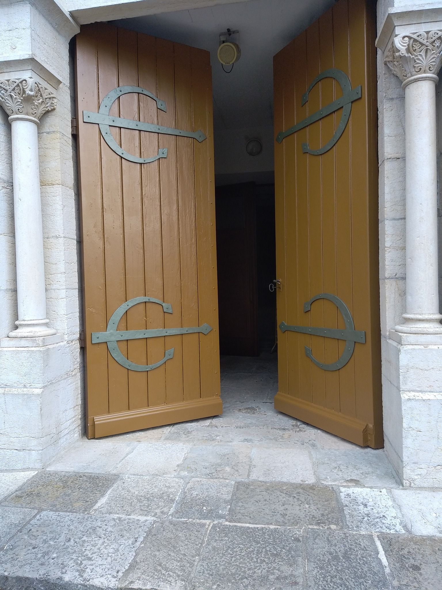 Des portes en bois marron avec des accents métalliques décoratifs.