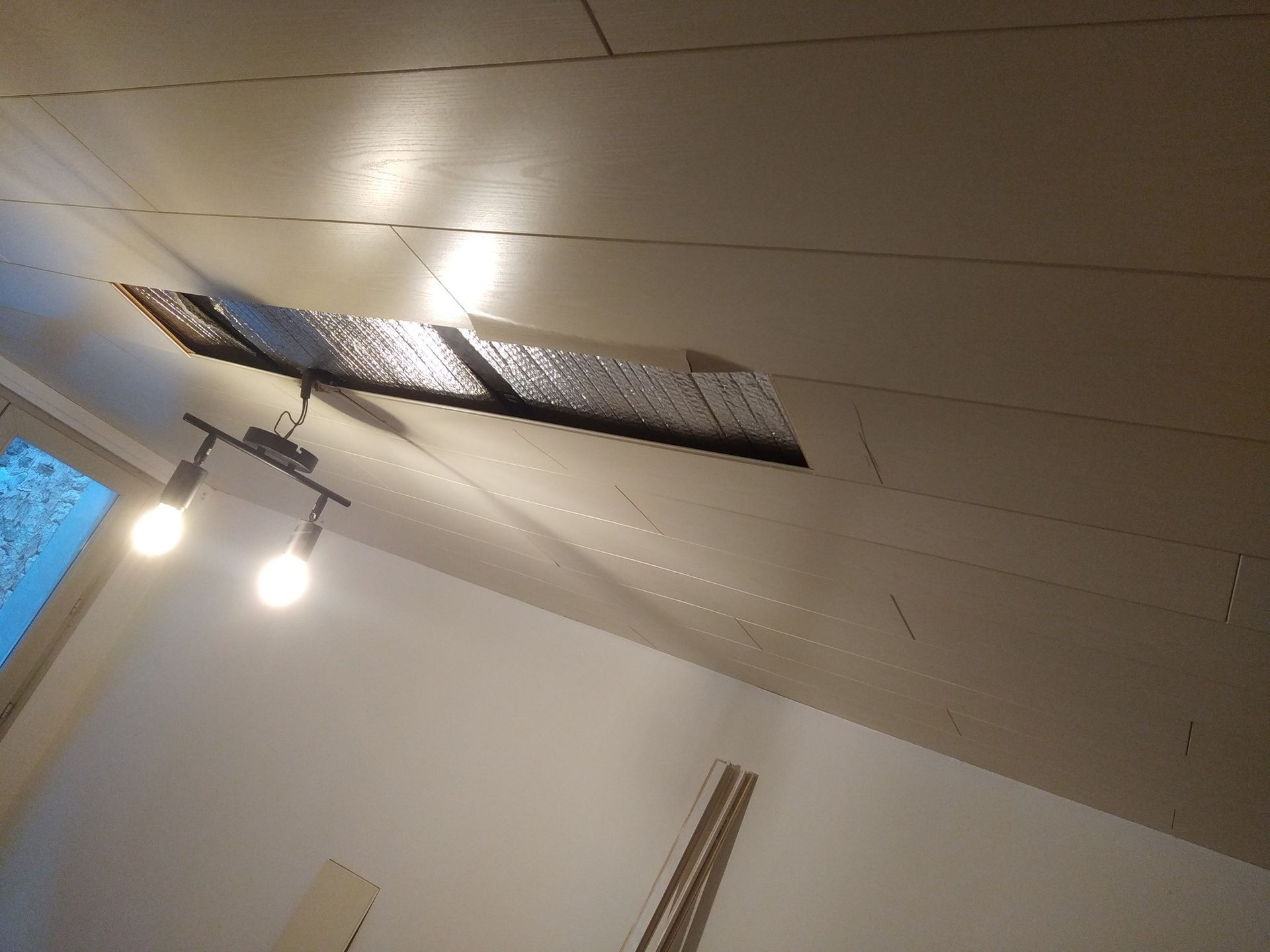 Plafond avec un luminaire et un trou rectangulaire.