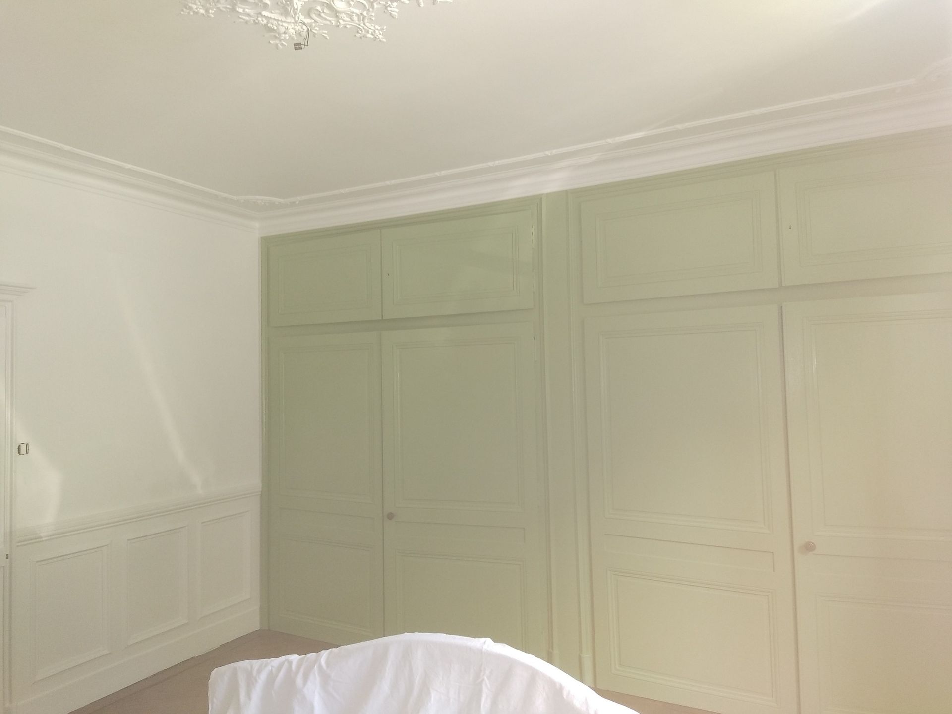 Placard encastré vert clair sur murs blancs.