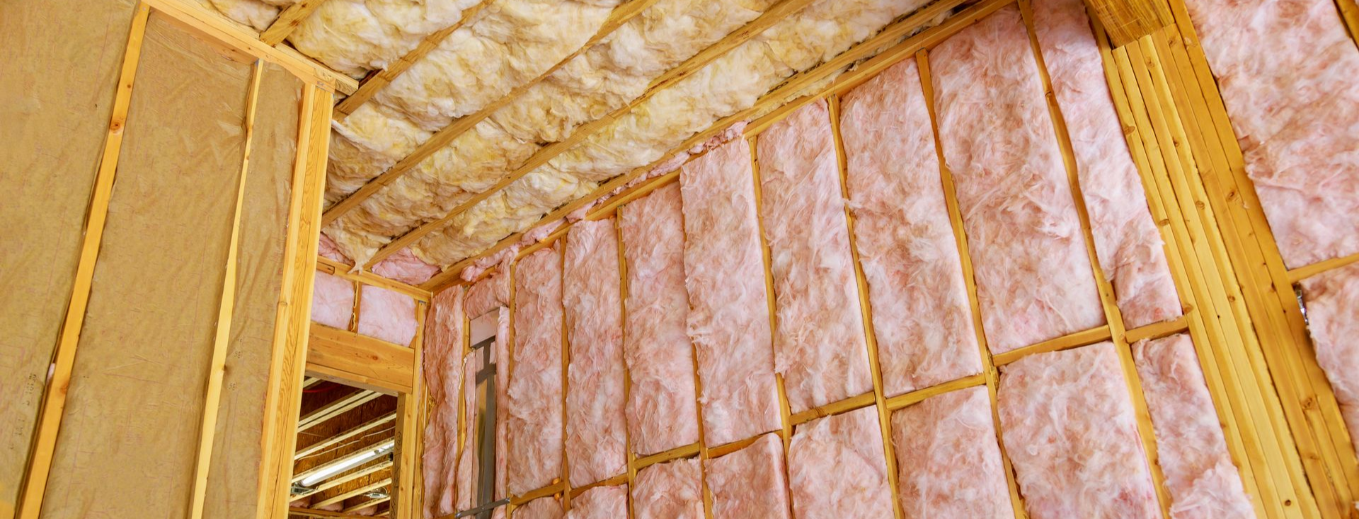 Intérieur d'un bâtiment en construction, isolé avec de la fibre de verre rose.