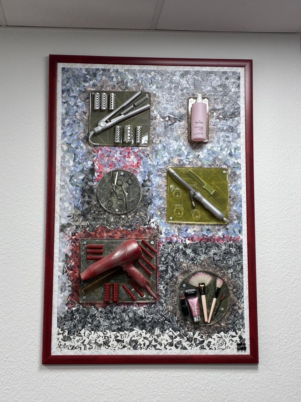 Kunstvolle Friseursalon-Werkzeuge: Glätteisen, Haarspray, Kamm, Bleistift, Föhn, Make-up-Pinsel in einem gerahmten Display.