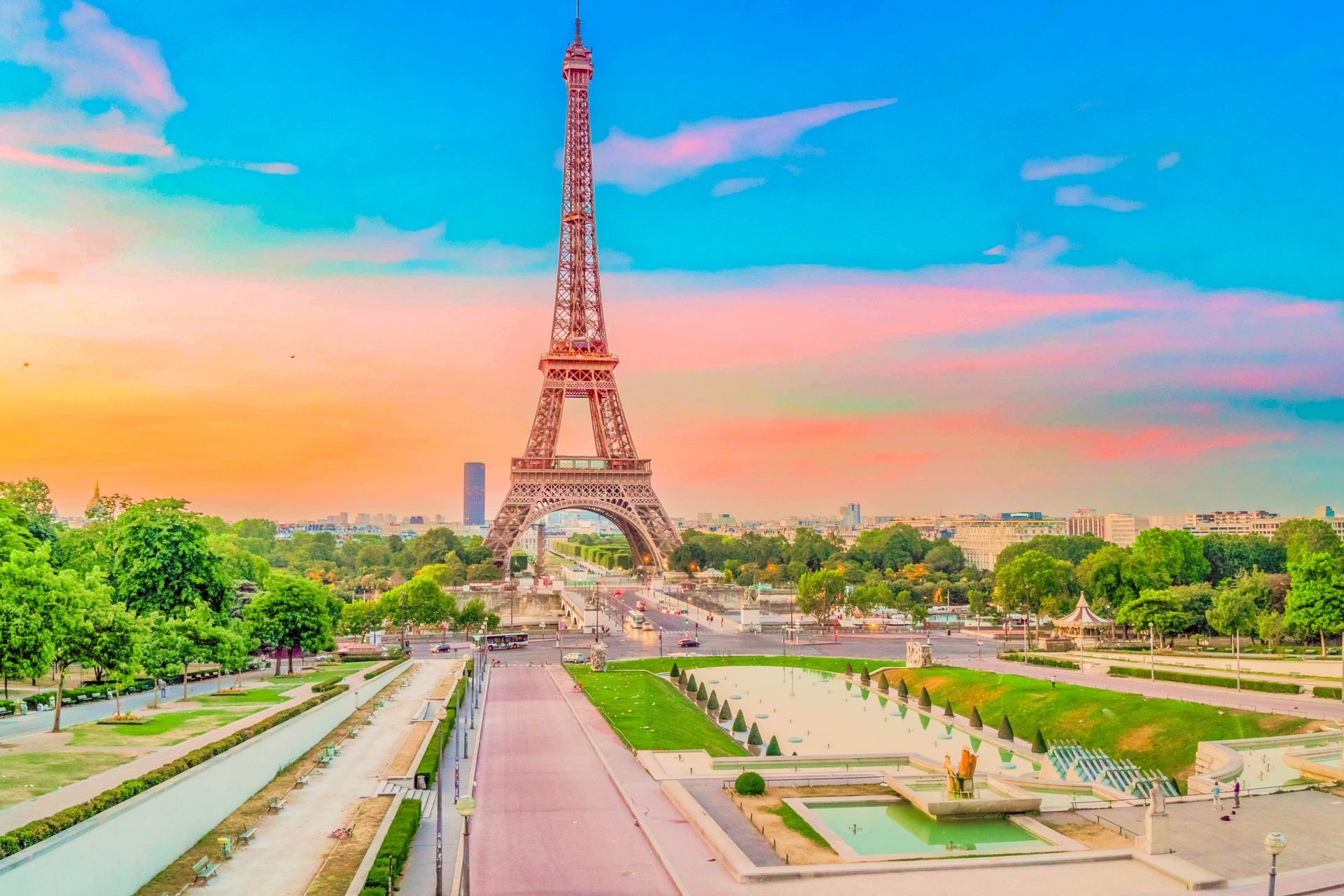 La tour Eiffel se dresse au centre, sous un coucher de soleil flamboyant, et domine un parc verdoyant.