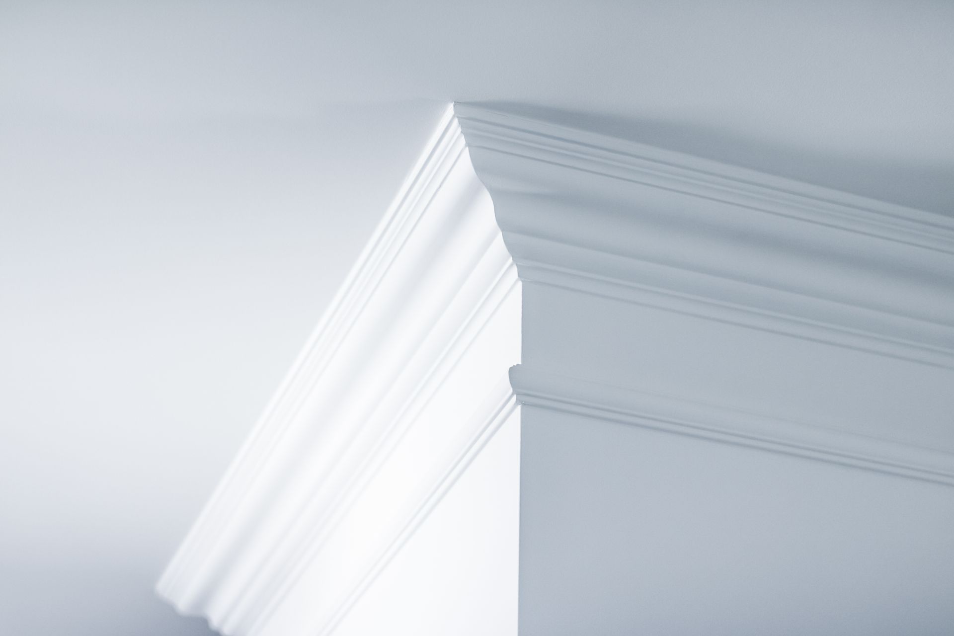 Moulure de corniche blanche installée à l'angle de deux murs.
