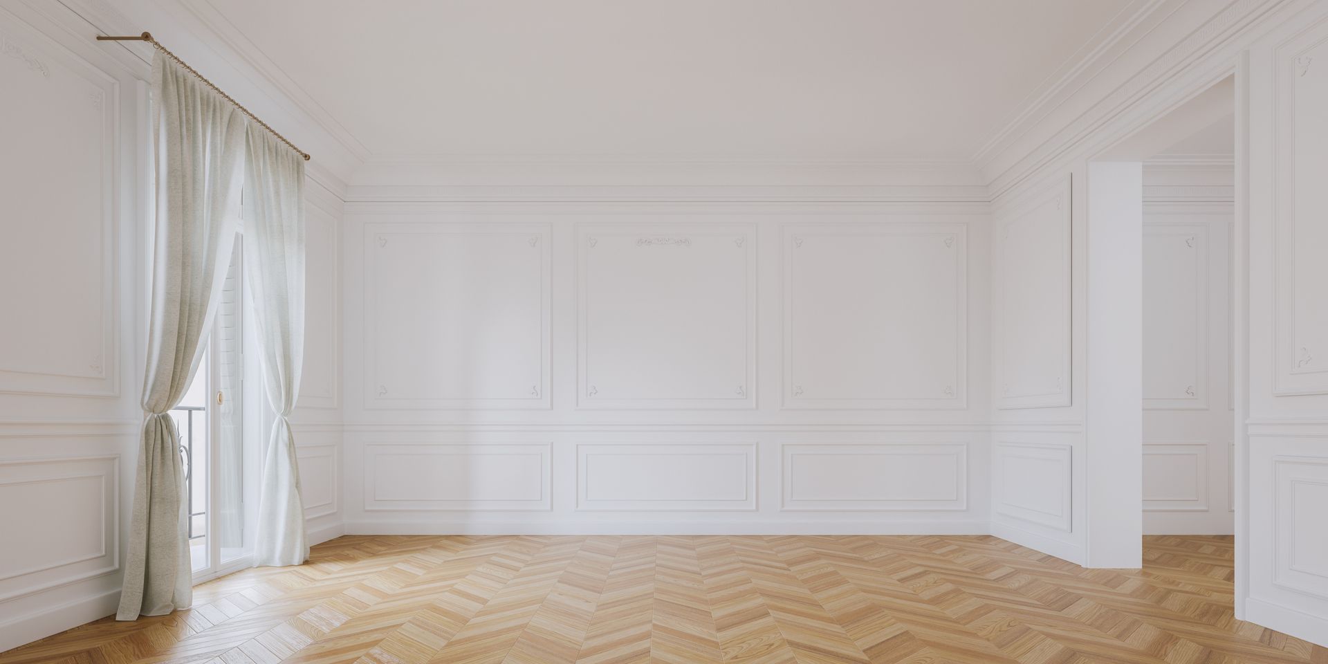 Une pièce vide aux murs lambrissés blancs, au parquet en chevrons et aux voilages blancs voilant une fenêtre.