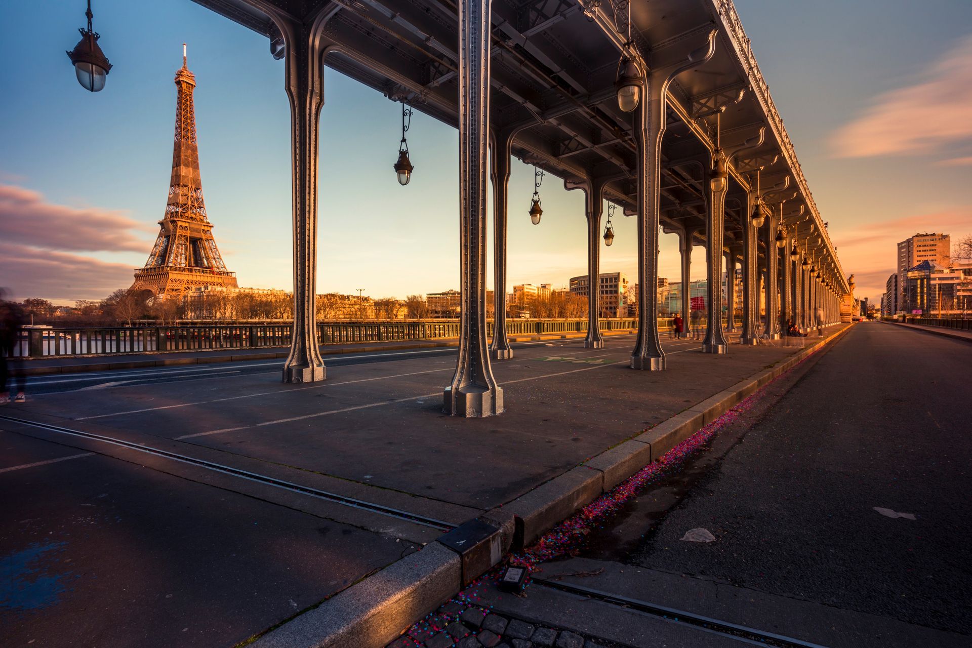 La tour Eiffel vue depuis le dessous des colonnes métalliques du pont de Bir-Hakeim au coucher du soleil.