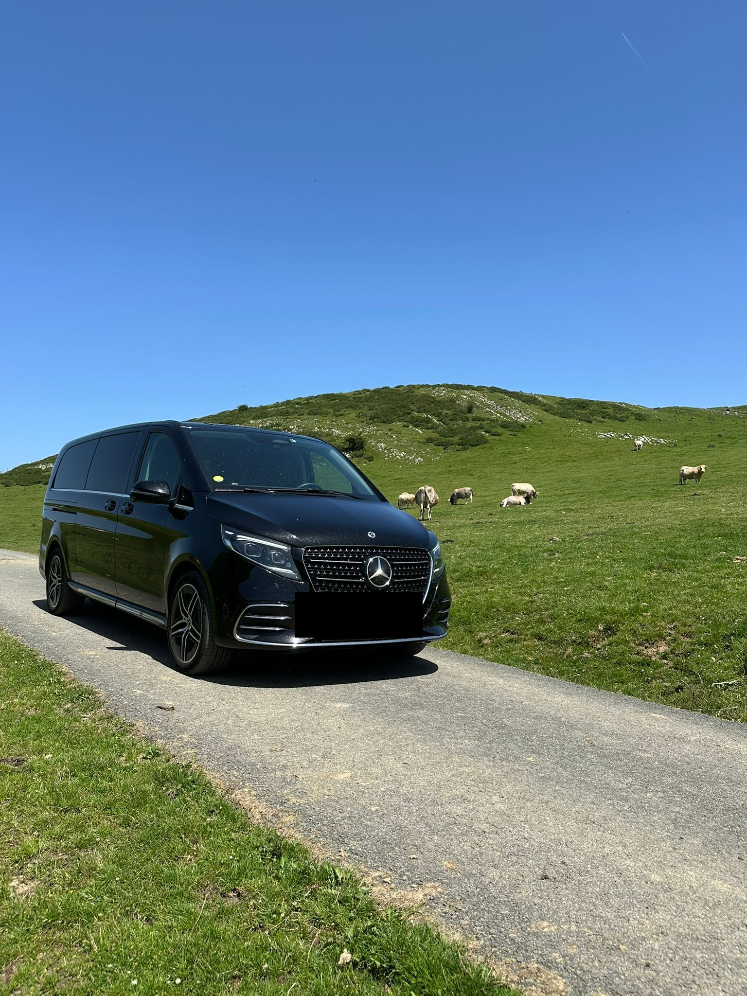 Un van noir roulant sur un chemin.