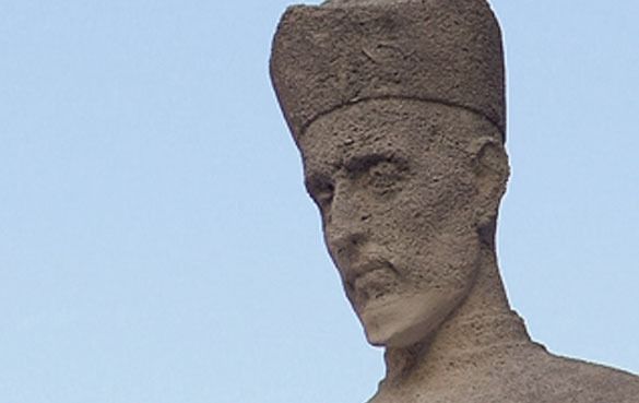 Una estatua de un hombre con un sombrero en la cabeza