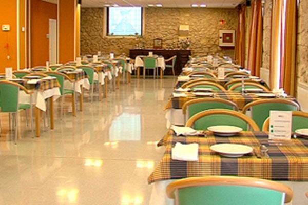 Un restaurante con mesas, sillas y platos.