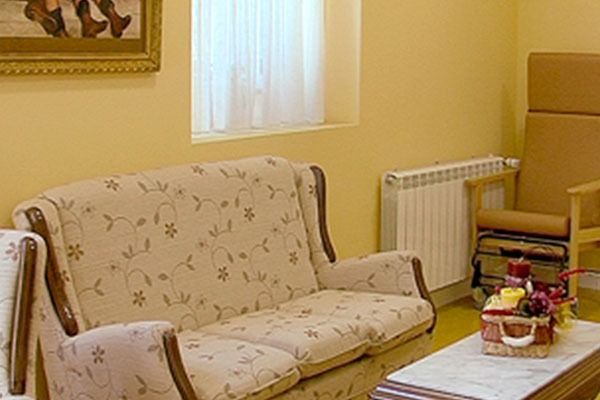 Una sala de estar con un sofá, una silla, una mesa y un cuadro en la pared.