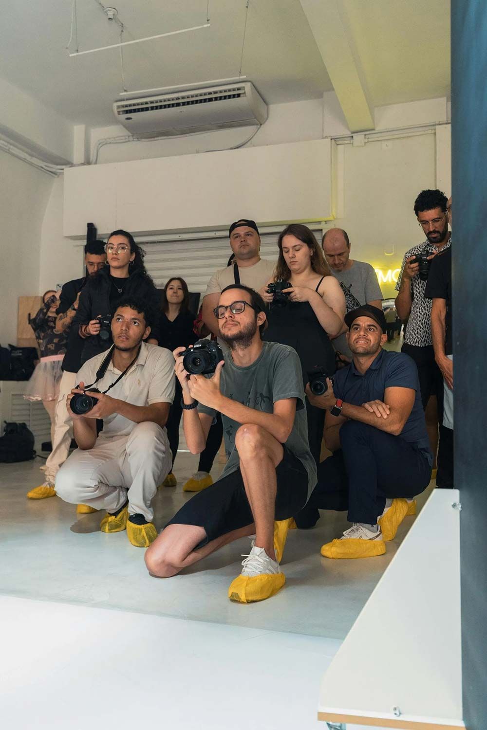 Un grupo de personas está arrodillada en una habitación tomando fotografías.