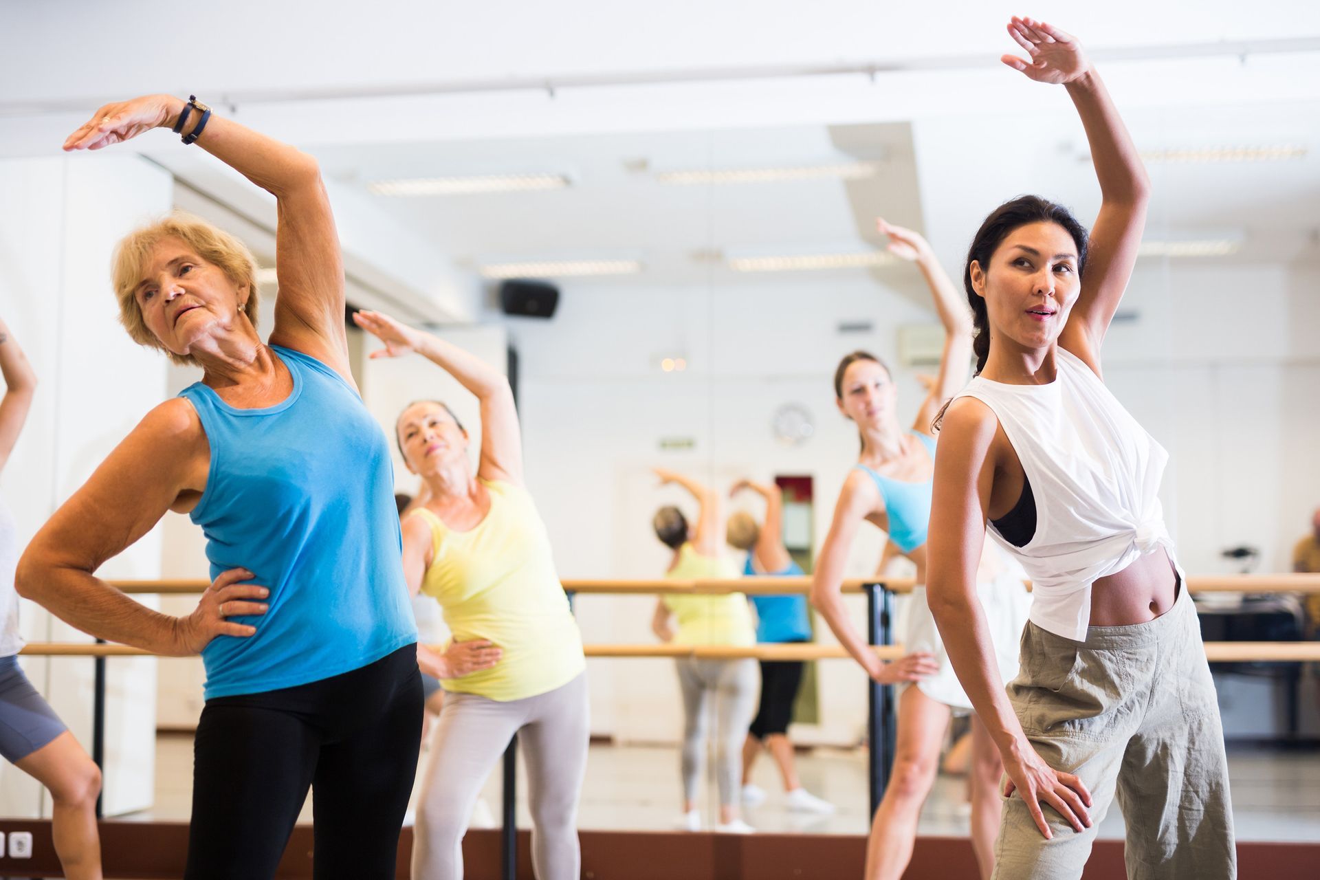 Un grupo de mujeres está haciendo ejercicios de estiramiento en un gimnasio.