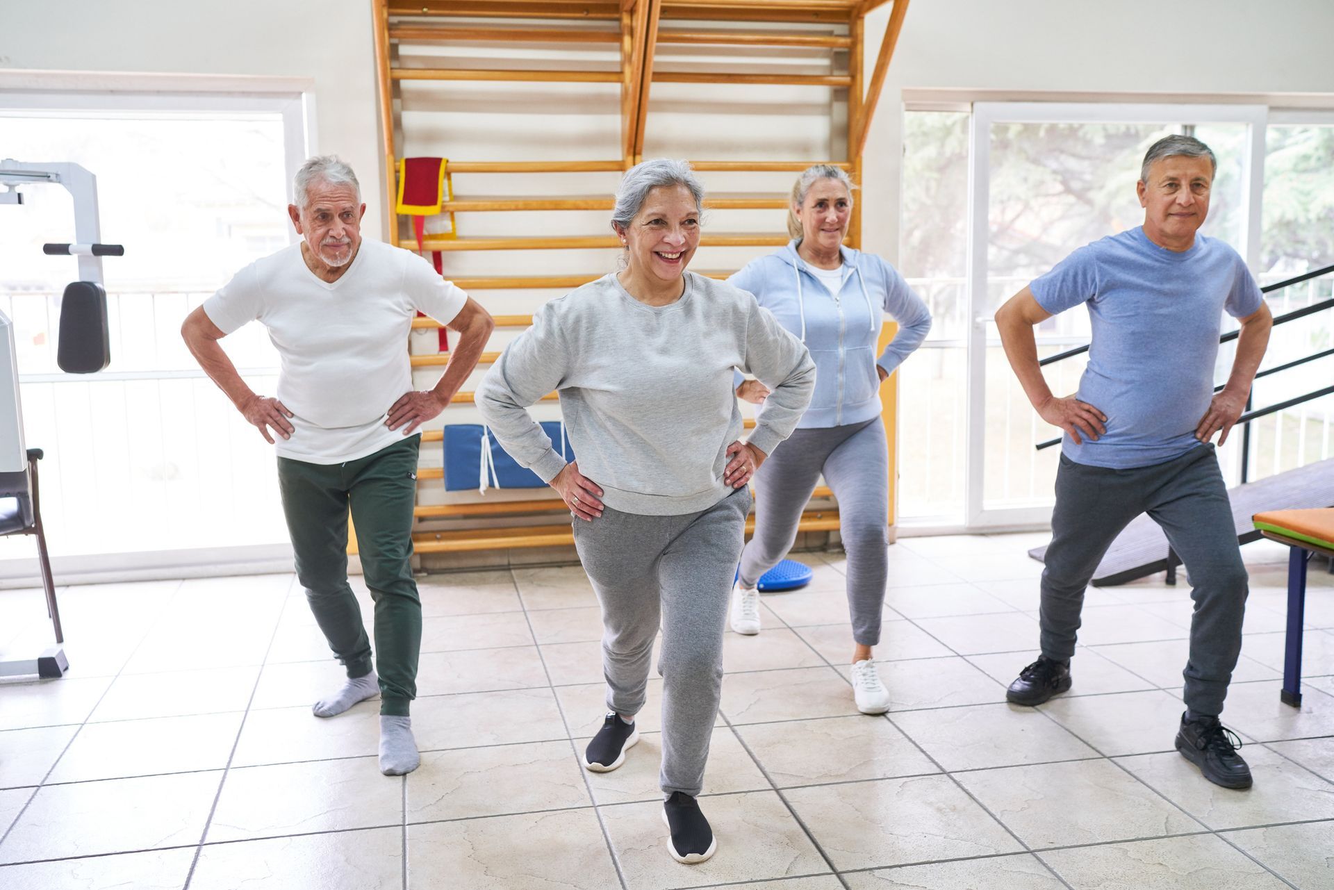 Un grupo de personas mayores está haciendo ejercicios en un gimnasio.