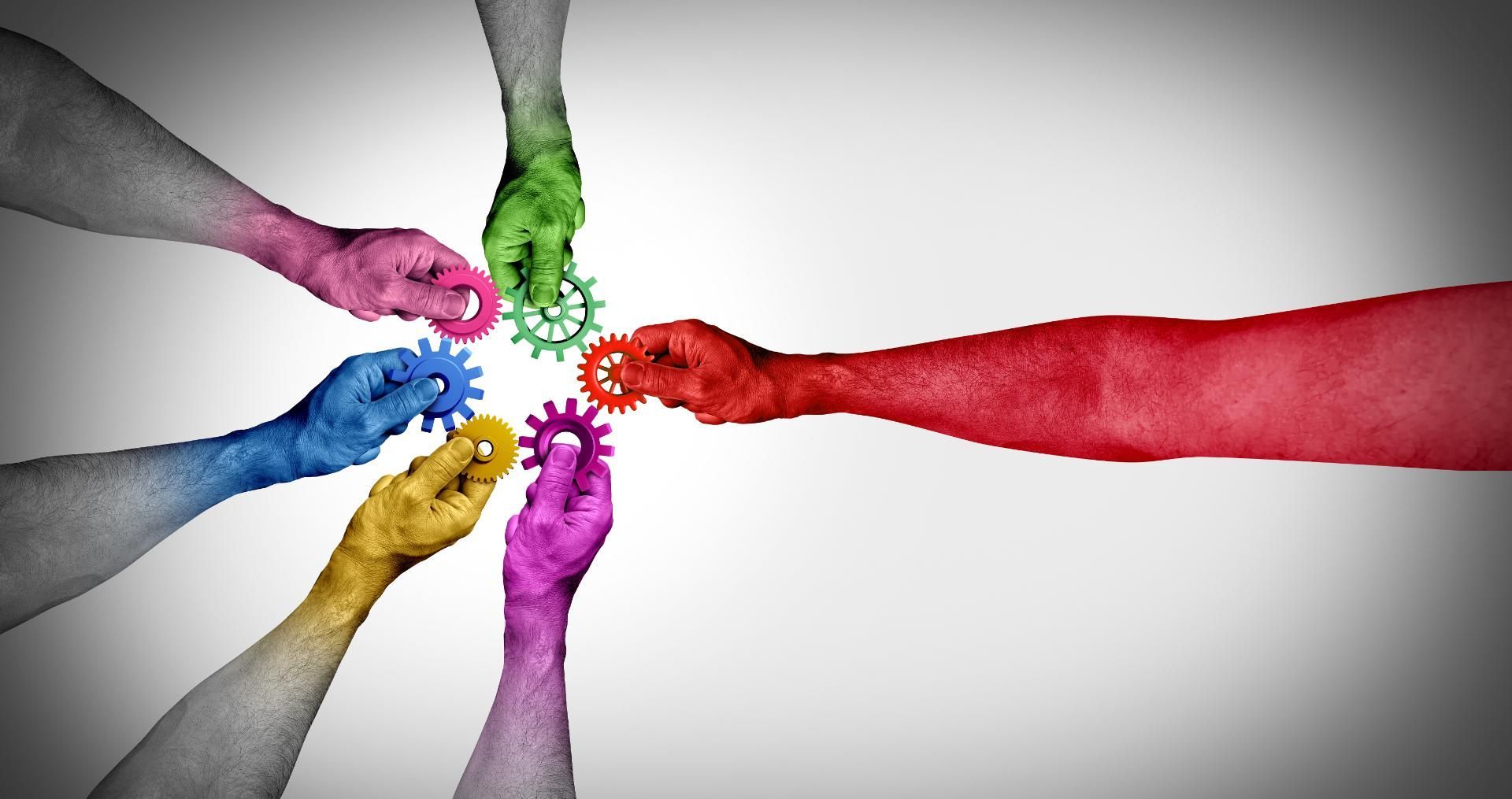 Eine Gruppe bunter Hände hält Zahnräder in einem Kreis.