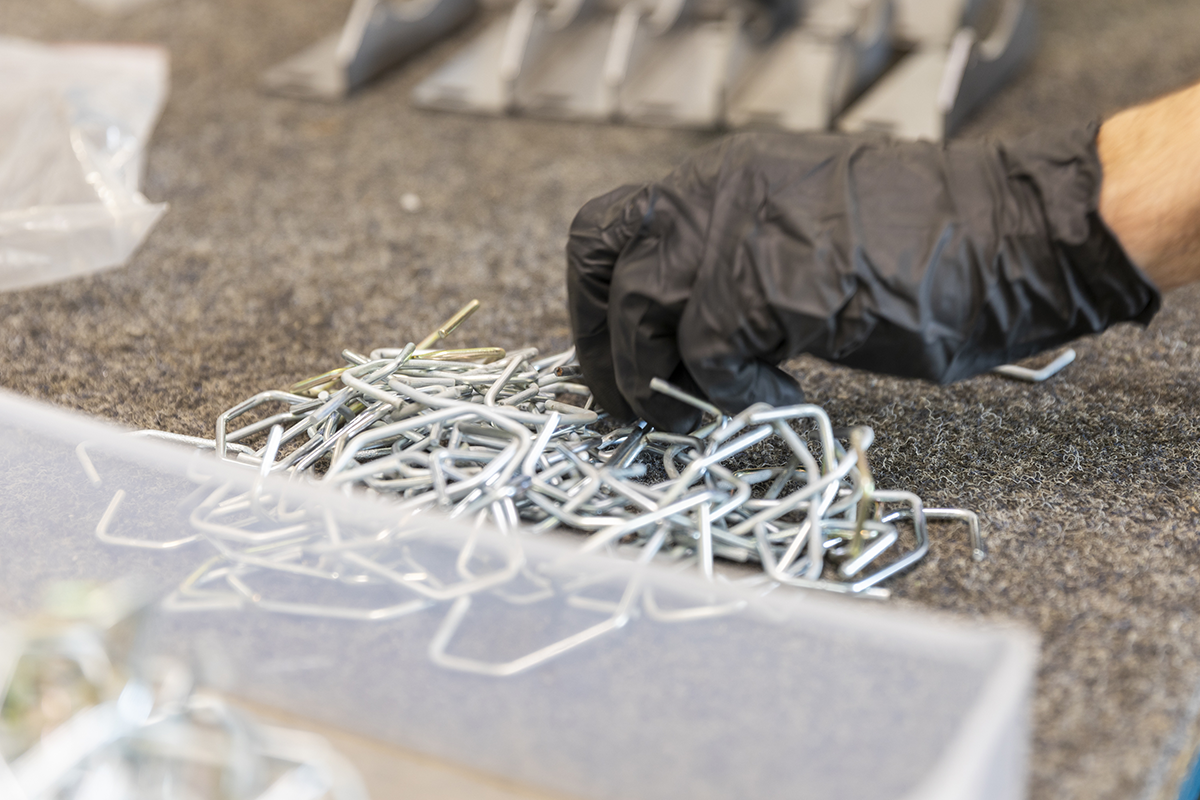 Une main dans un gant en train de trier des pièces métalliques