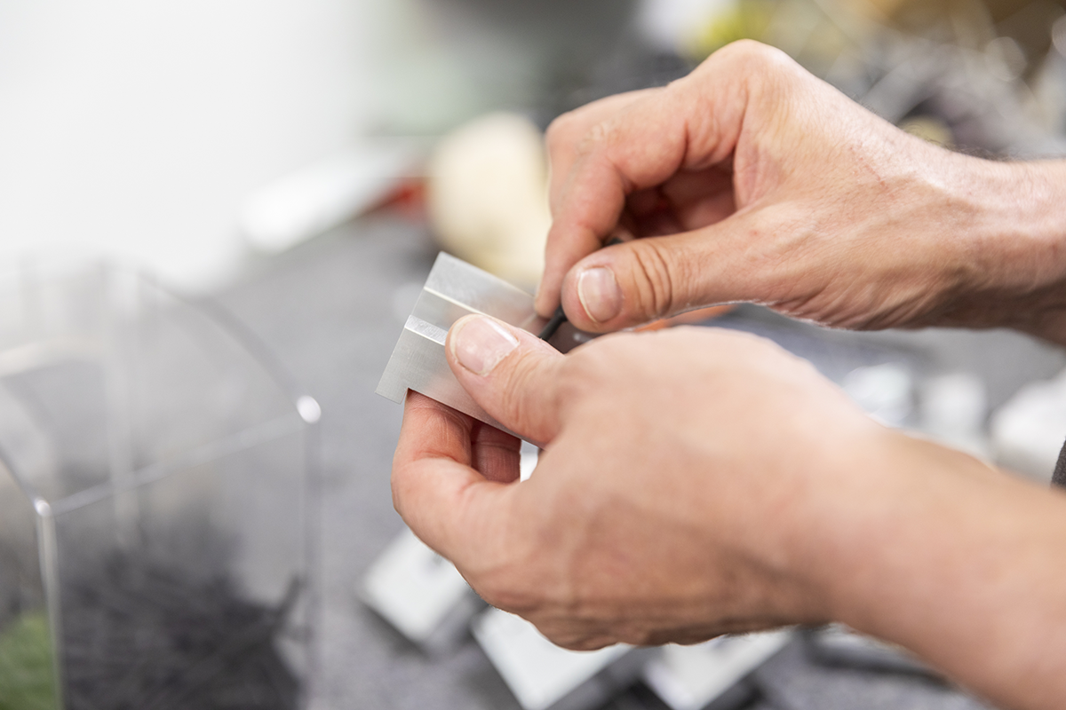Une personne qui tient une pièce en aluminium