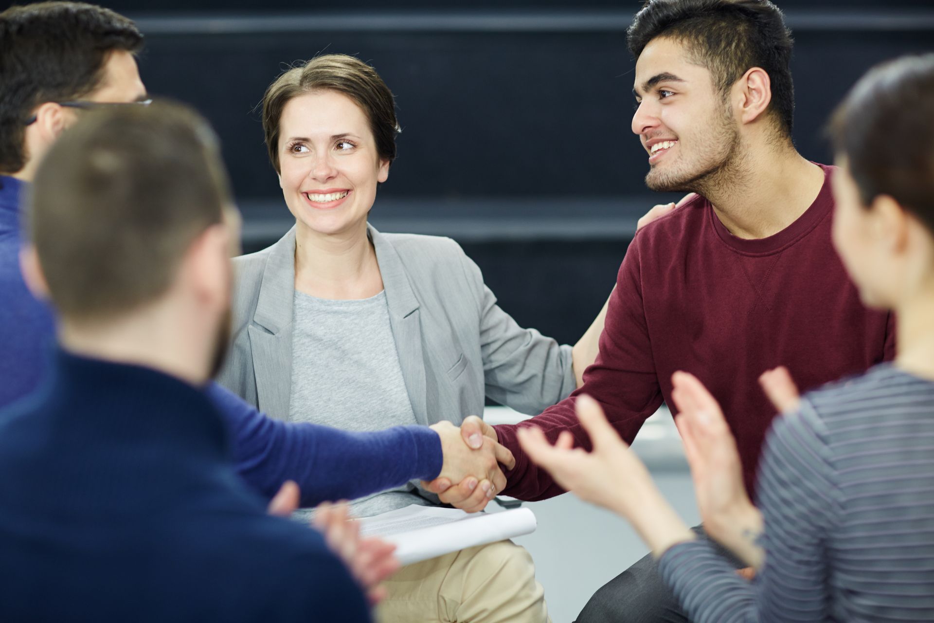 Avocate entourée de personnes souriantes organise une médiation familliale