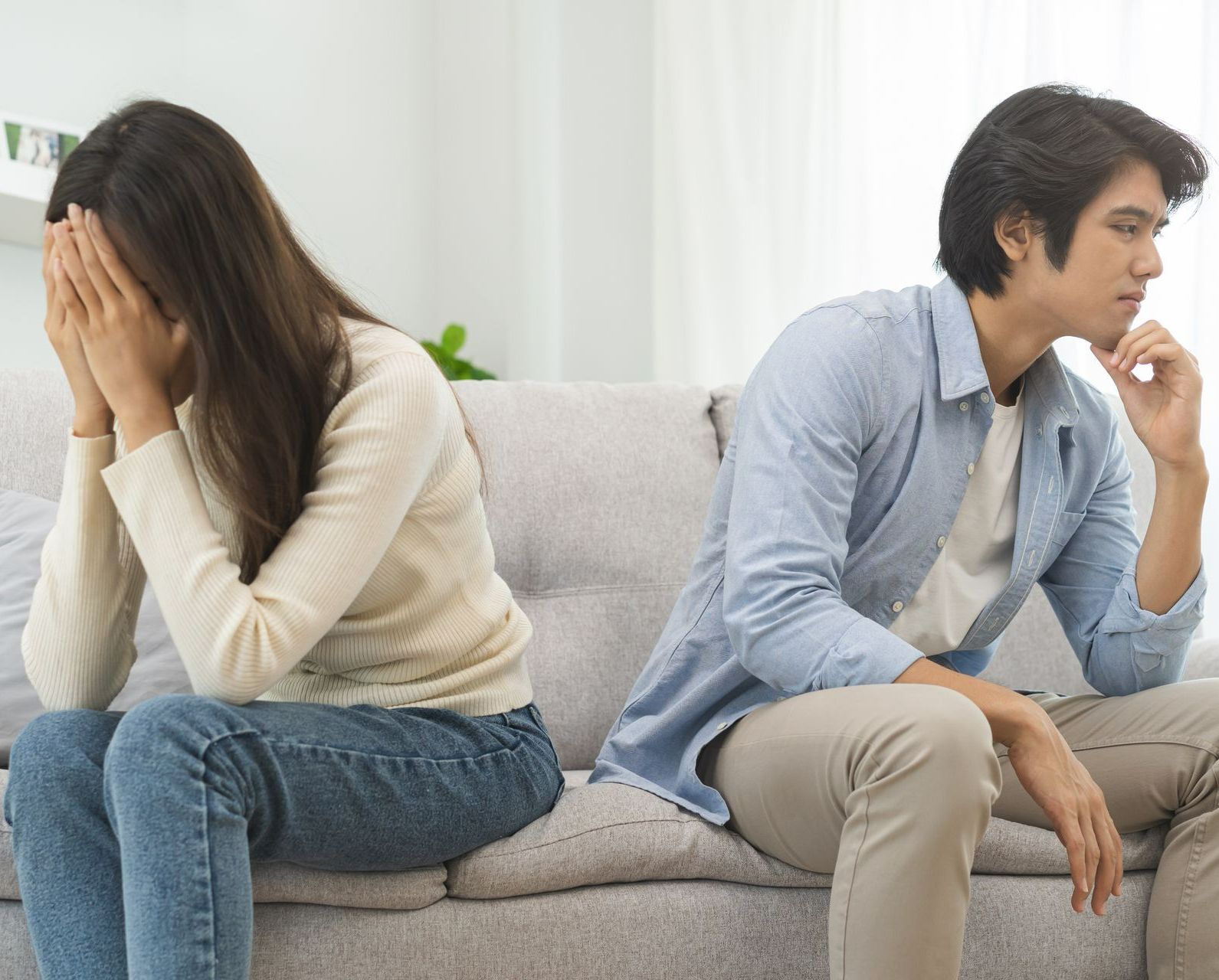 Couple dos-à-dos sur un canapé