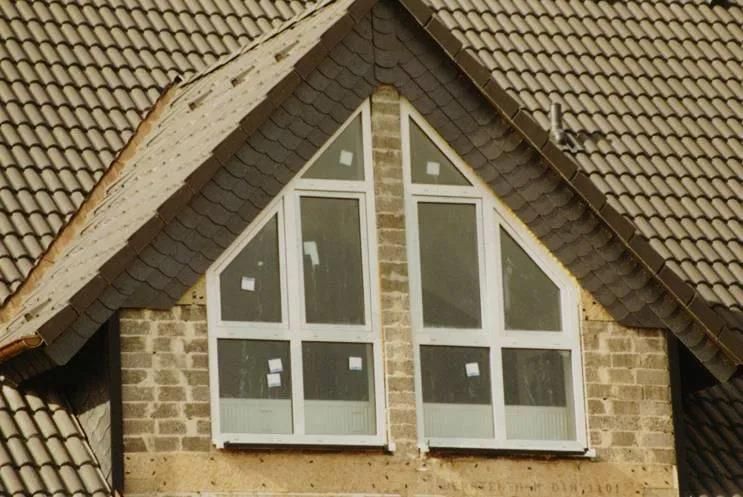Ein Haus mit einem dreieckigen Fenster auf dem Dach