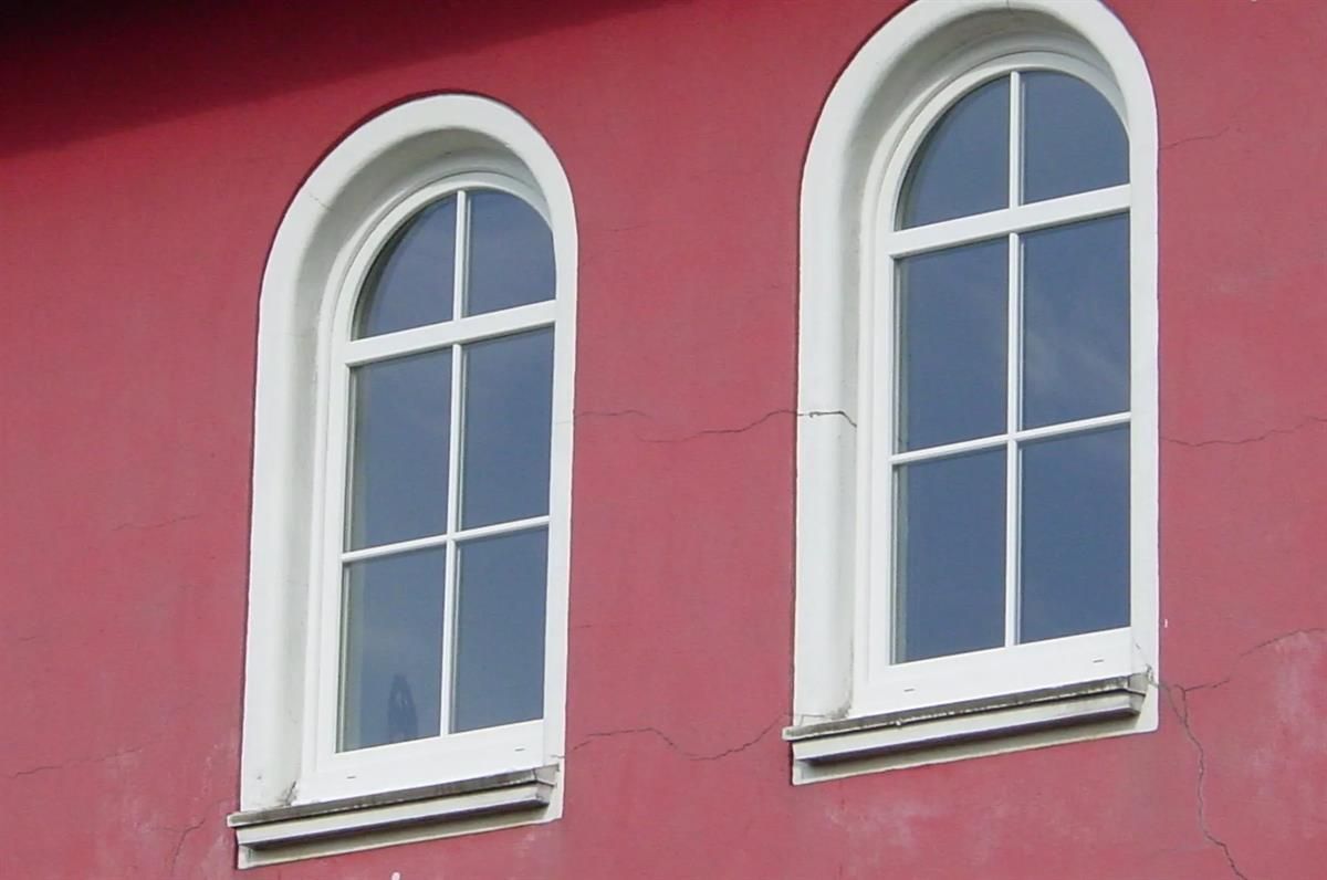 Zwei Bogenfenster an einem roten Gebäude