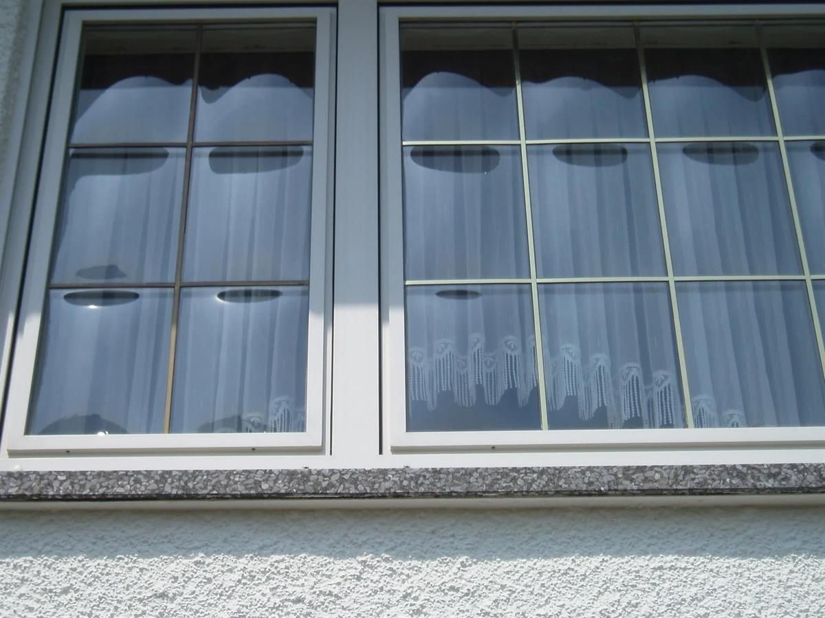 Ein Fenster mit einem weißen Vorhang