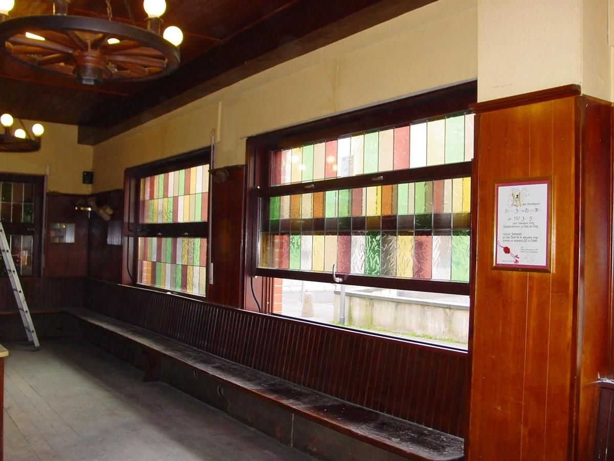 Ein Flur mit Buntglasfenstern und einem Schild an der Wand