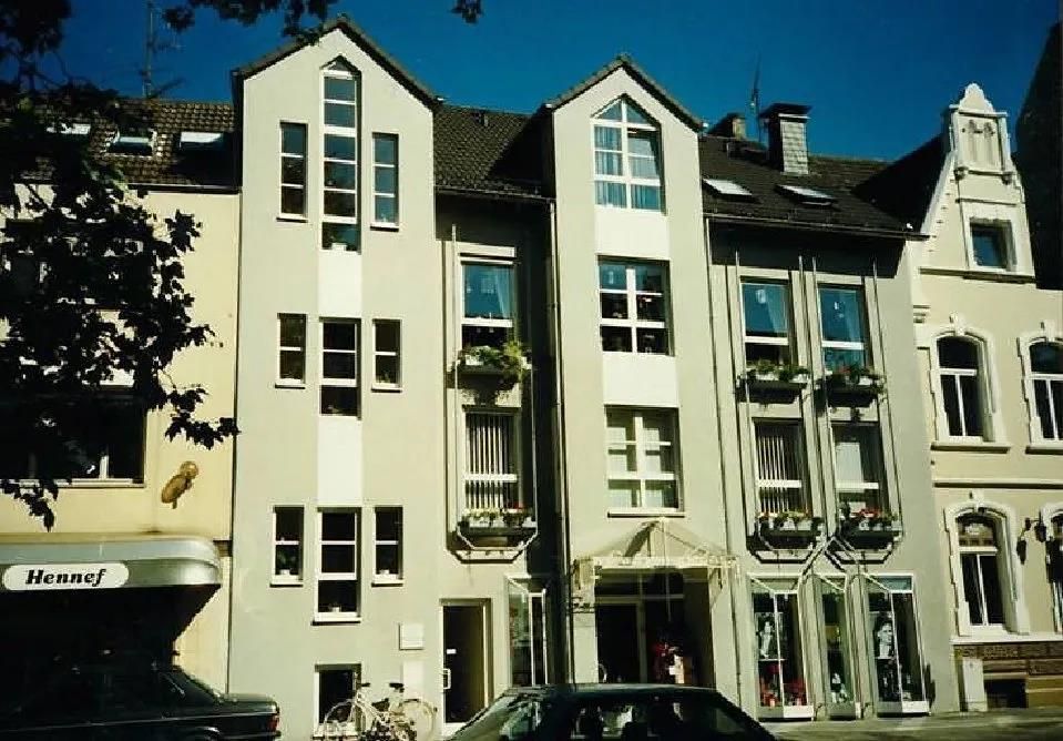 Ein Auto steht vor einem Gebäude, auf dem ein Schild mit der Aufschrift „Allianz“ steht.