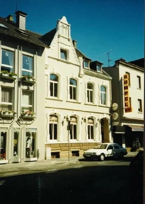 Ein weißes Auto steht vor einem großen weißen Gebäude