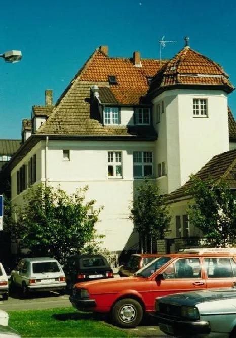 Ein rotes Auto steht vor einem weißen Gebäude