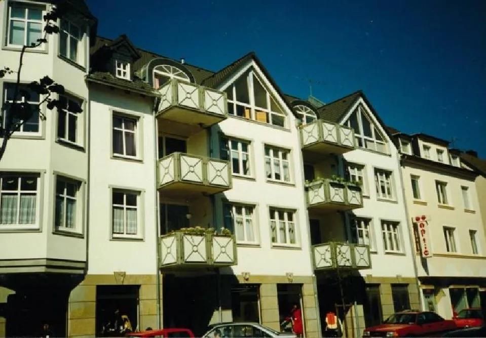 Ein weißes Gebäude mit einem davor geparkten roten Auto