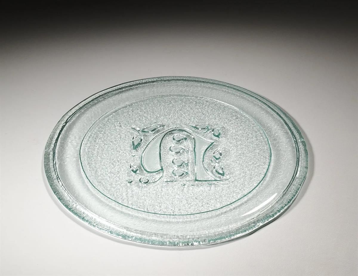 Eine klare Glasplatte mit einem Monogramm darauf