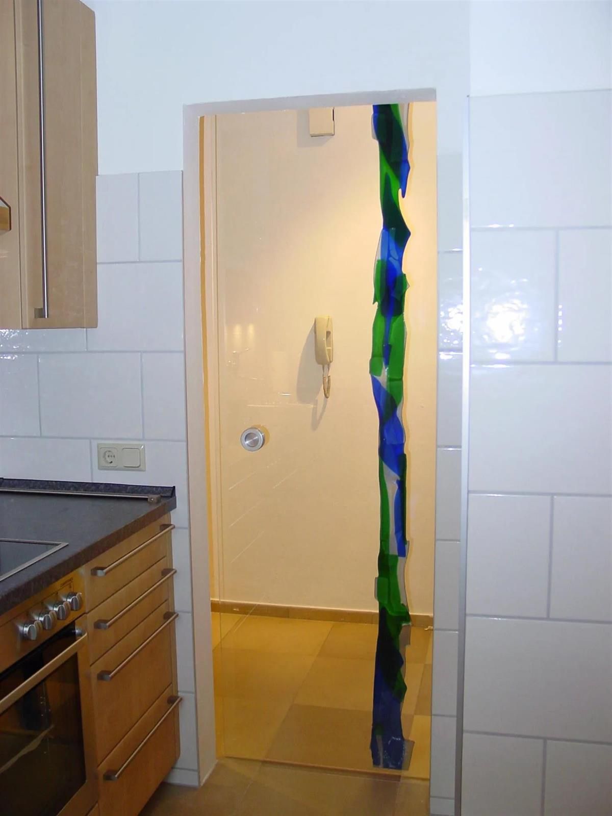 Eine Küche mit offener Tür und einem Telefon an der Wand