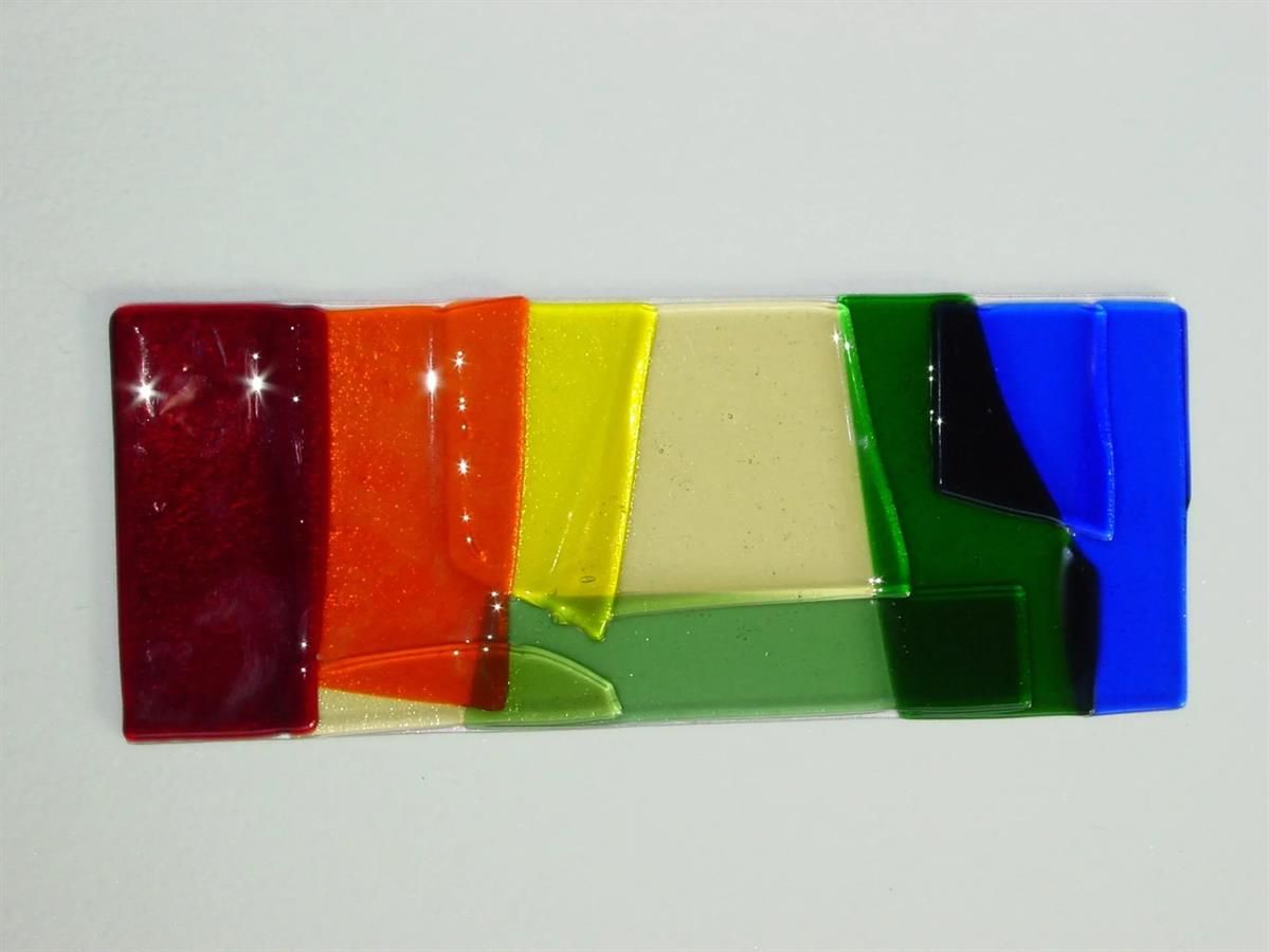 Ein Haufen verschiedenfarbiger Glasstücke auf einer weißen Oberfläche