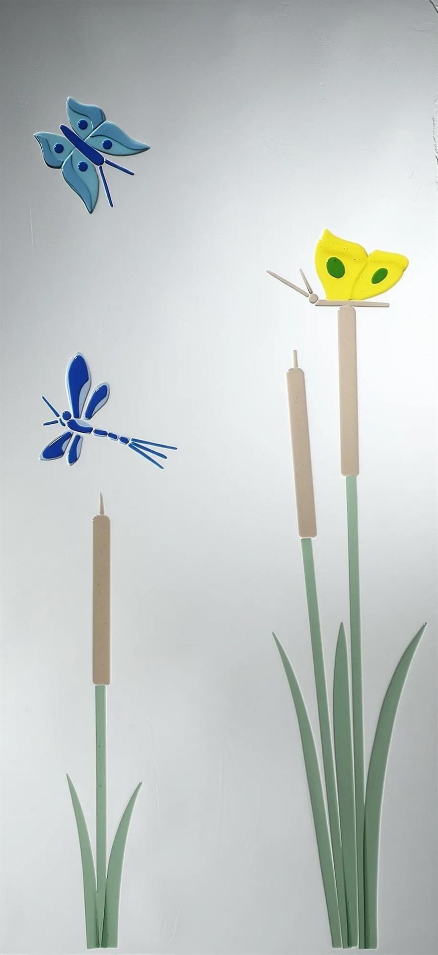 Ein Schmetterling sitzt auf einer Blume neben einer Libelle