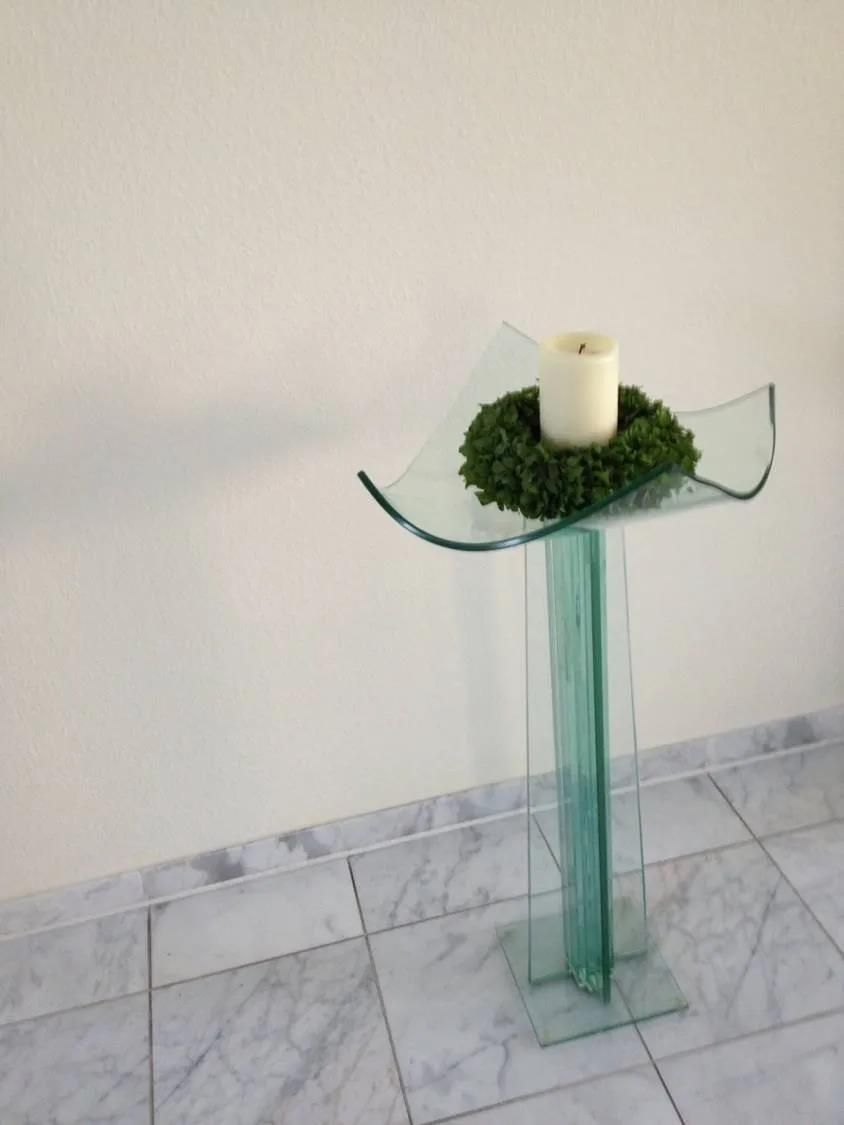 Ein Glastisch mit einer Kerze darauf