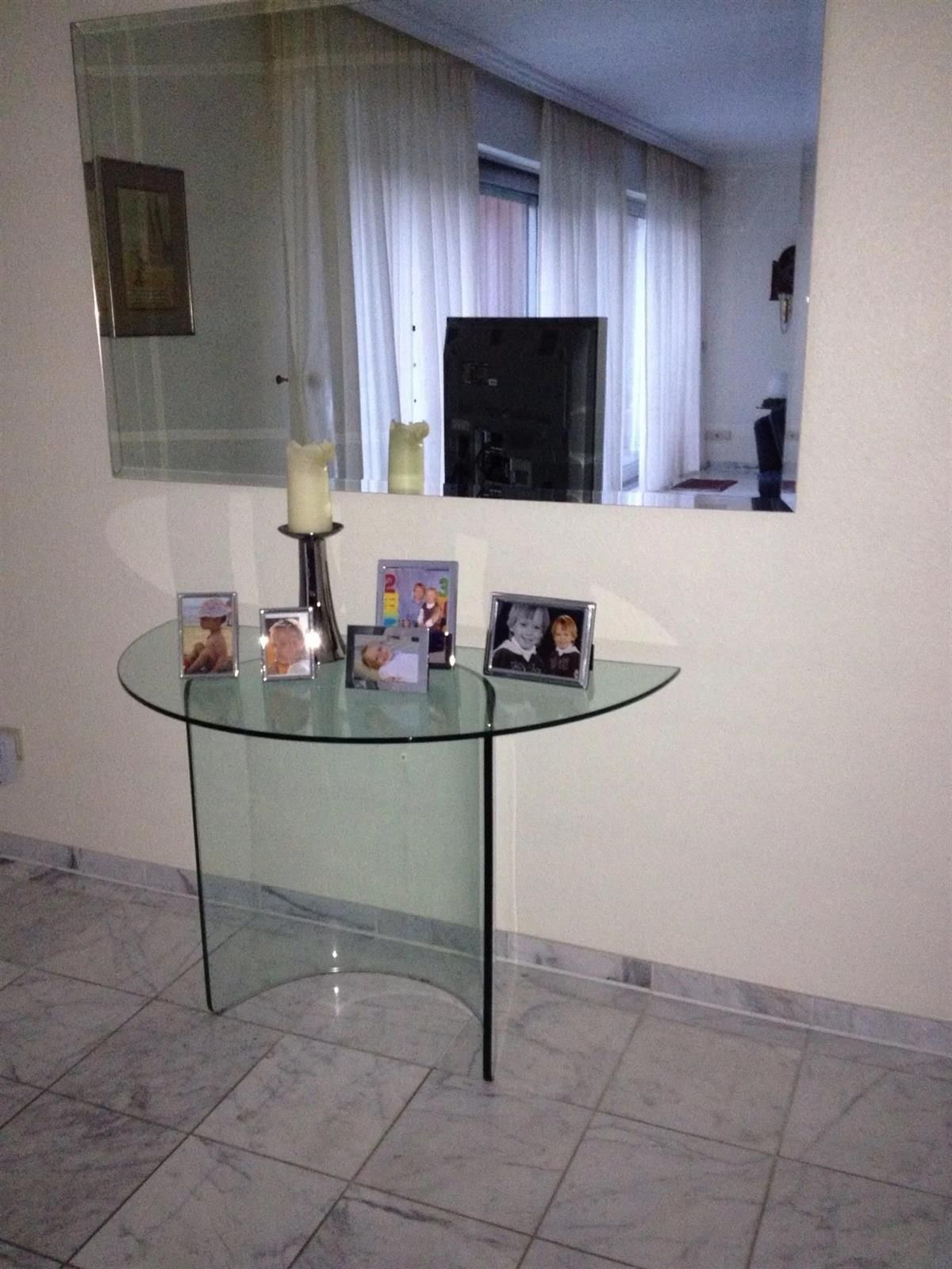 Ein Glastisch mit einer Kerze darauf in einem Raum