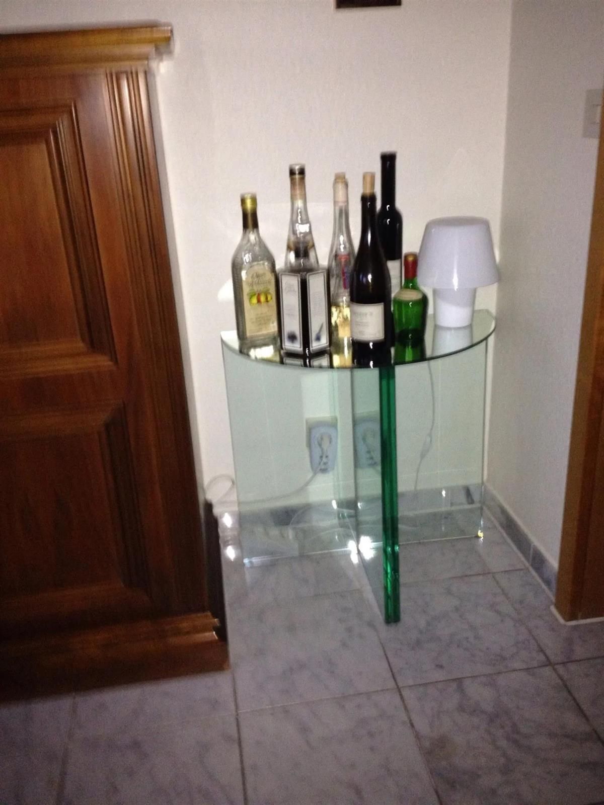 Mehrere Flaschen Alkohol stehen auf einem Glastisch