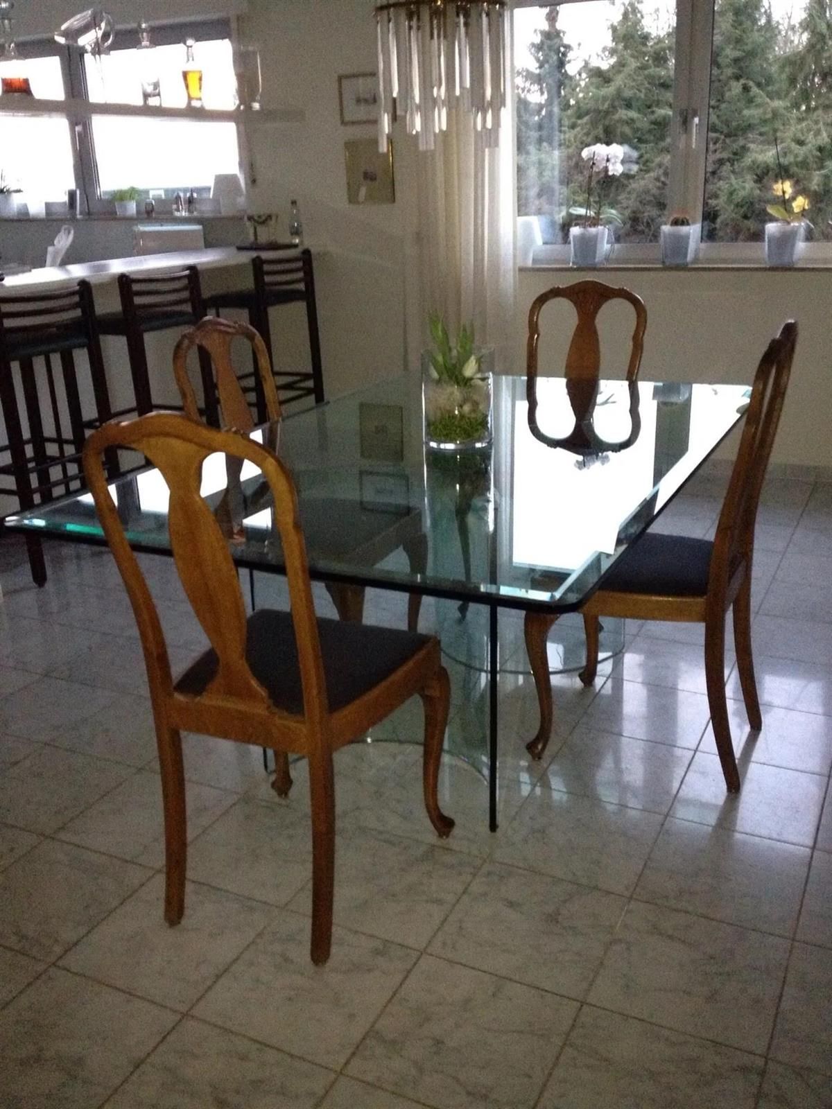 Ein Esszimmer mit Glastisch und Stühlen
