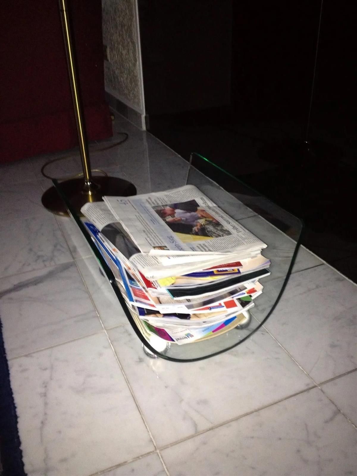 Ein Stapel Zeitschriften liegt auf einem Glastisch