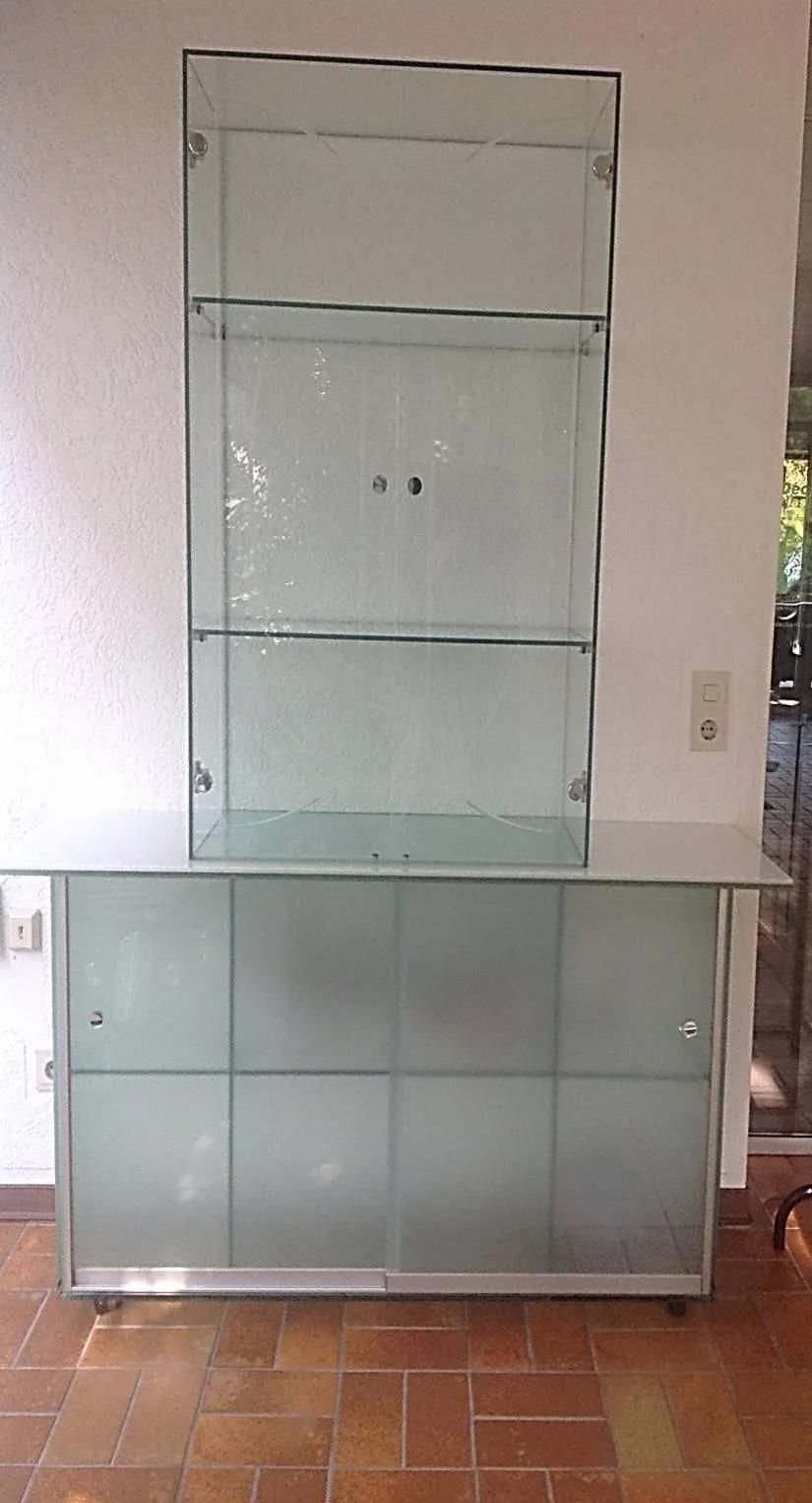 In einem Raum steht eine Glasvitrine auf einem gefliesten Boden.