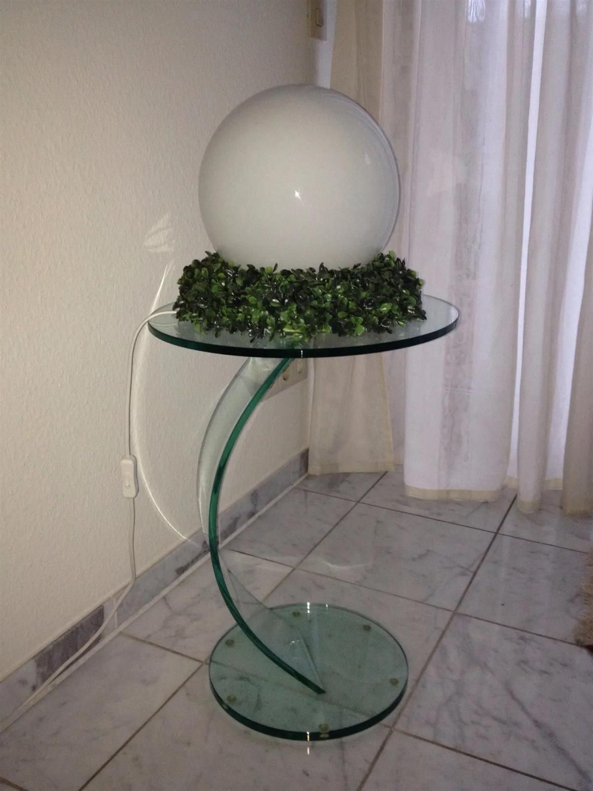 Ein Glastisch mit einer weißen Kugel darauf