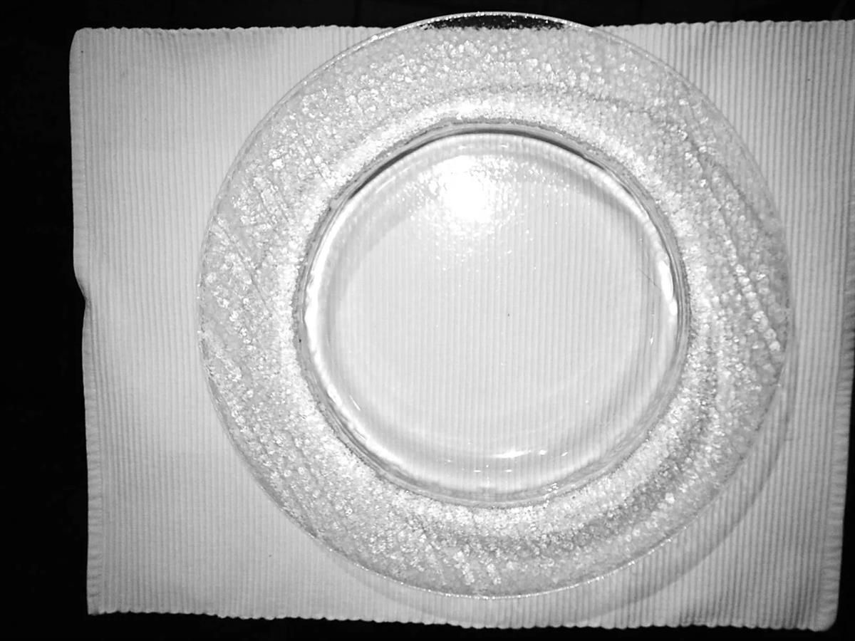 Ein Schwarzweißfoto einer Glasplatte auf einem Tisch.