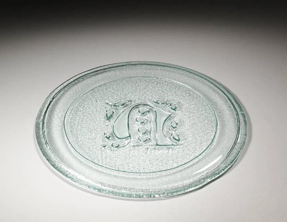 Eine klare Glasplatte mit dem Buchstaben K darauf